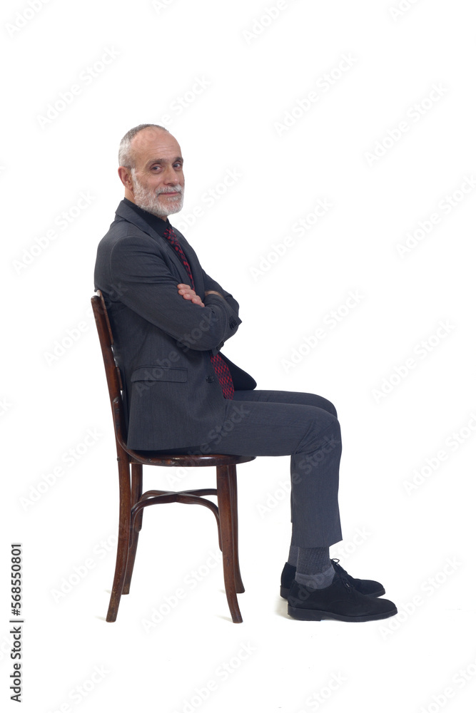 side view of a man sitting on chair with suit and tie and arms crossed and looking at camera on white background side view of a man sitting on chair with suit and tie and arms crossed and looking at camera on white background