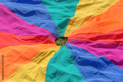 Kids play parachute for outdoor education. Rainbow colors fabric toy for childrens development games