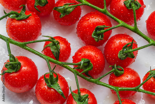 Fototapeta Naklejka Na Ścianę i Meble -  Cherry tomatoes sprayed with water. A cluster of tomato fruits. Food background