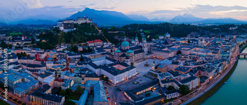Beautiful aerial drone panorama of Salzburg city in Austria during night. View of the historic city of Salzburg and Salzach river at summer.
