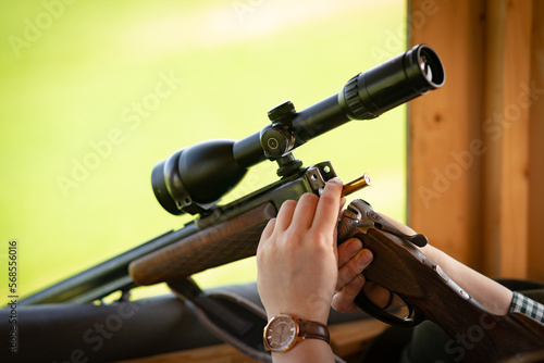 Laden einer Jagdwaffe mit Munition auf einen Hochsitz.