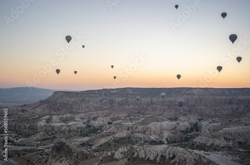 Views of Cappadocia from above, hot air balloons over the valley at dawn