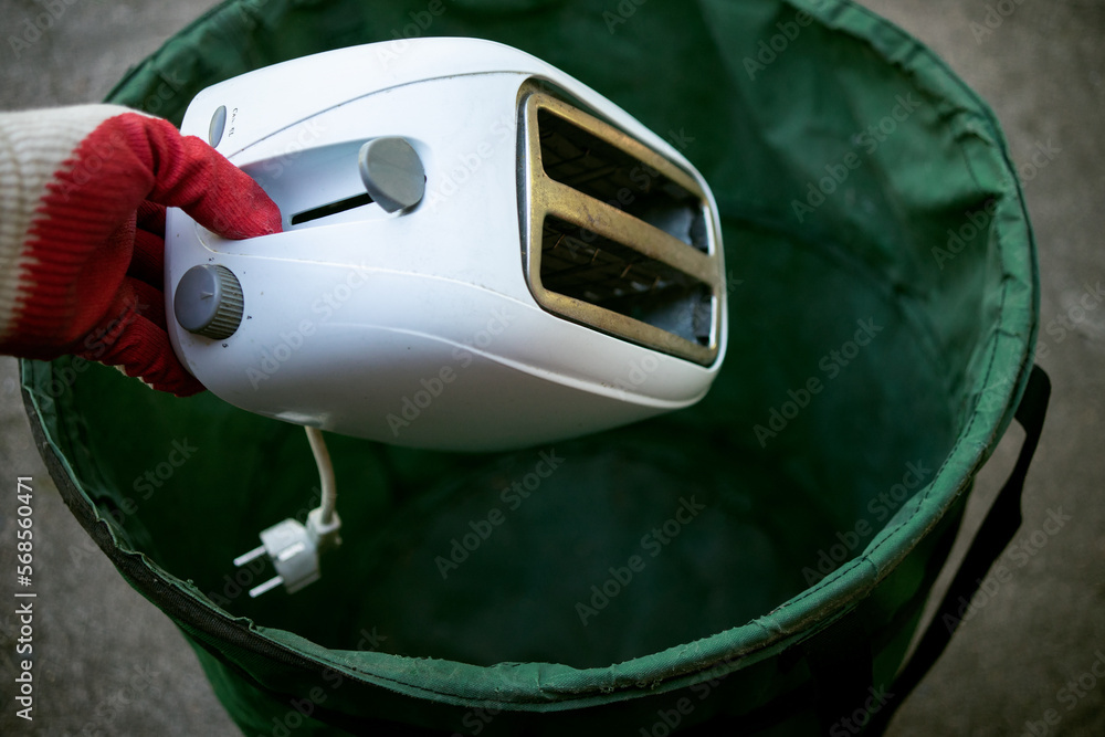 Throw old household appliances in the trash.A hand throws a sandwich