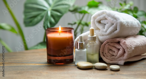 Spa and wellness setting with scented candle, massage oils and towels, relaxing spa still life