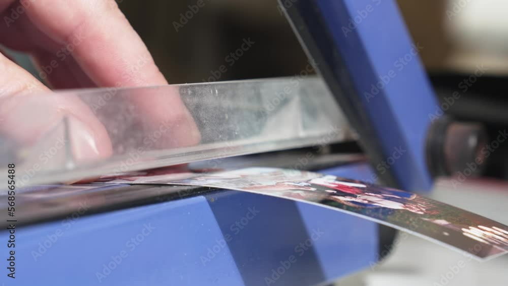narrow depth of field. Men's hands cut photos on the cutter. narrow depth of field. Men's hands cut photos on the cutter.