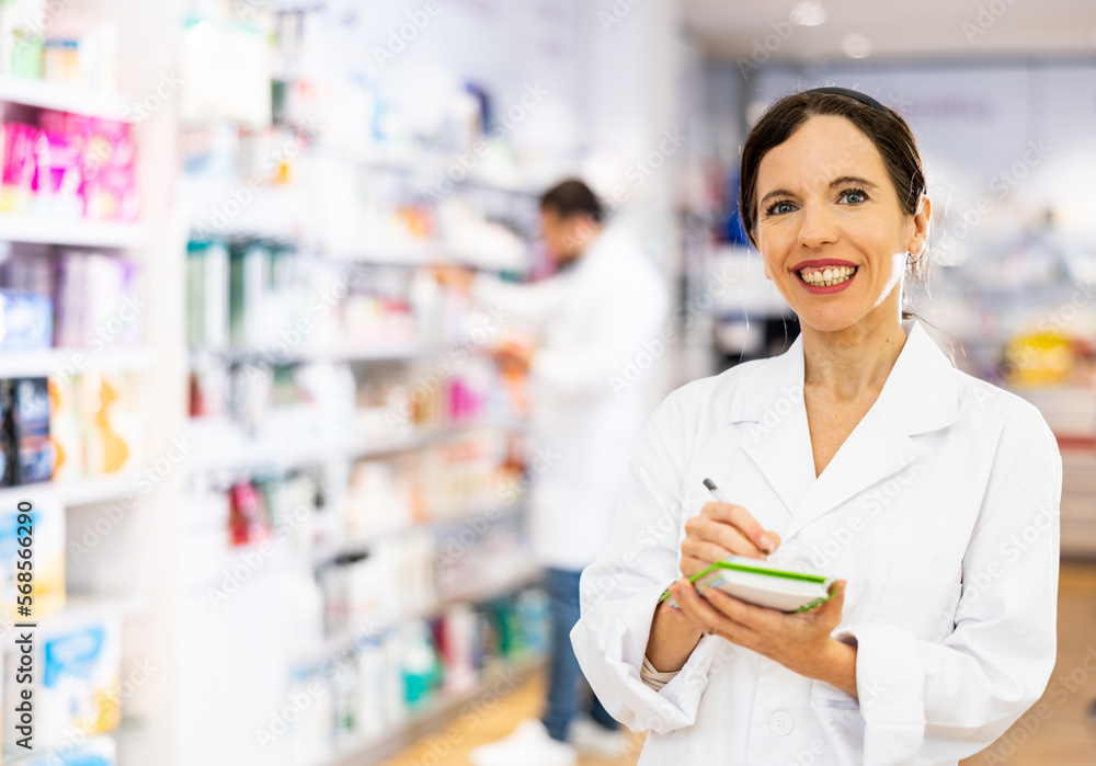 Young adult woman pharmacist holding notepad and pen working at pharmacy