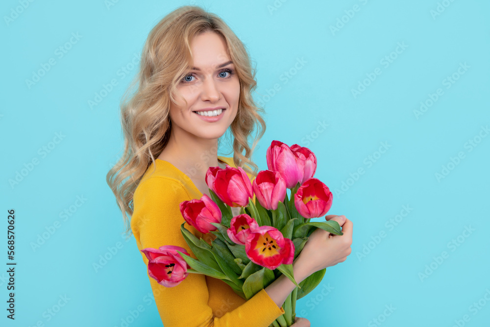 young woman smile with spring tulip flowers on blue background. march 8 young woman smile with spring tulip flowers on blue background. march 8