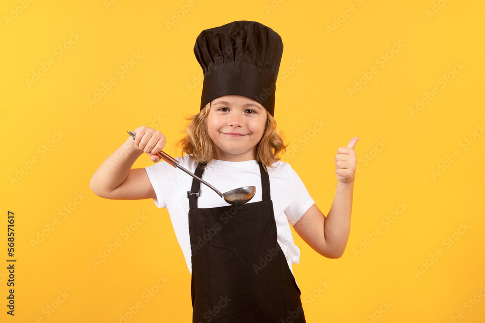 Funny kid chef cook with kitchen ladle, studio portrait. Kid chef cook prepares food on isolated studio background. Kids cooking. Teen boy with apron and chef hat preparing a healthy meal. Funny kid chef cook with kitchen ladle, studio portrait. Kid chef cook prepares food on isolated studio background. Kids cooking. Teen boy with apron and chef hat preparing a healthy meal.