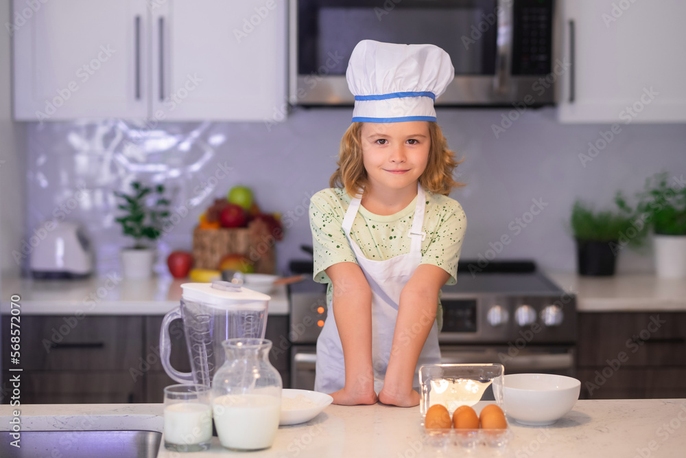 Funny child stand at kitchen table have fun baking, doing bakery preparing food at home kithen. Funny child stand at kitchen table have fun baking, doing bakery preparing food at home kithen.