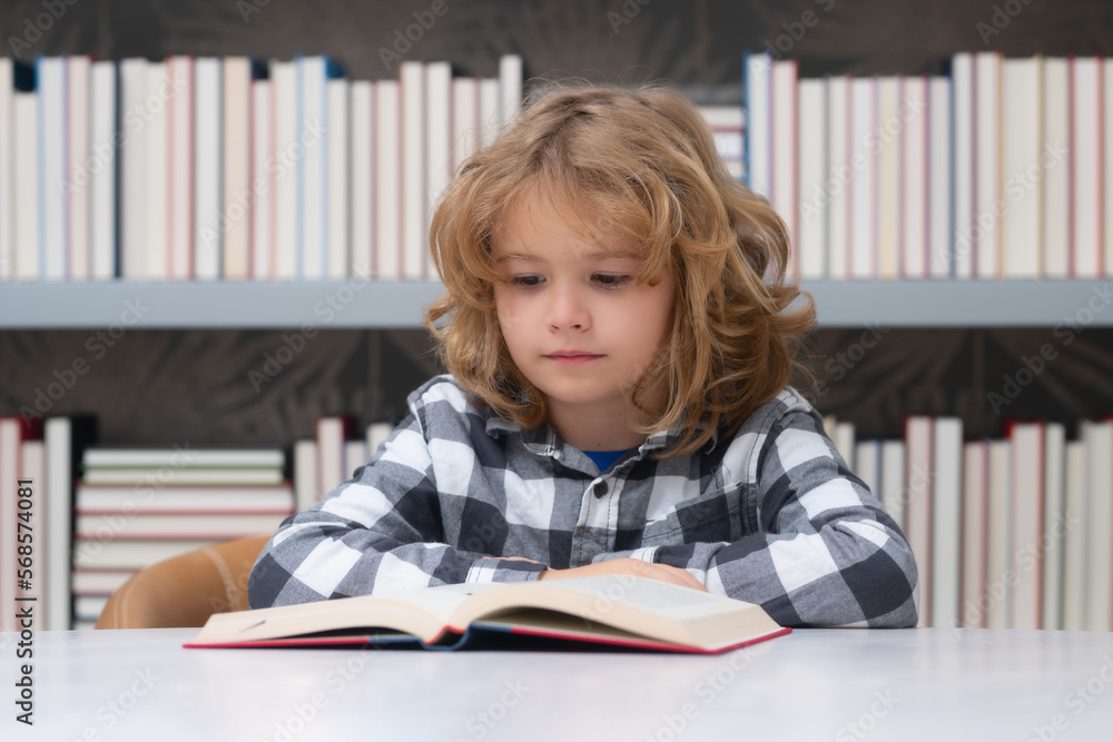 Education and school concept. Portrait of school boy reading book in library. Kids development, learn to read. Child boy sitting in a book store, reading books. Education and school concept. Portrait of school boy reading book in library. Kids development, learn to read. Child boy sitting in a book store, reading books.