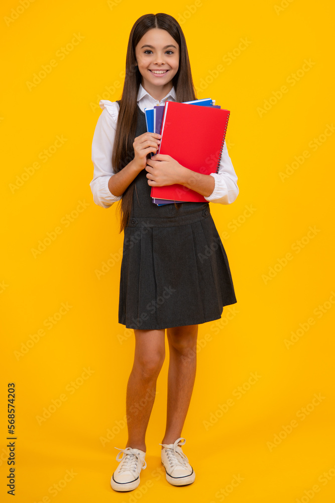 Teen girl pupil hold books, notebooks, isolated on yellow background, copy space. Back to school, teenage lifestyle, education and knowledge. Teen girl pupil hold books, notebooks, isolated on yellow background, copy space. Back to school, teenage lifestyle, education and knowledge.