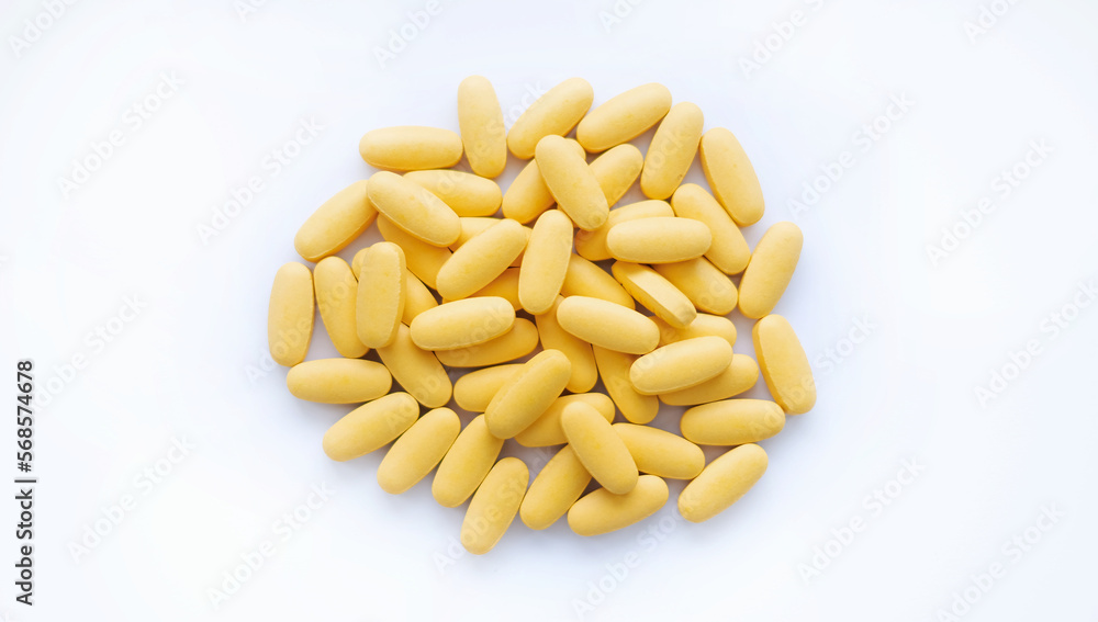 Close-up texture of yellow multivitamin tablets on white background. Healthy lifestyle concept Close-up texture of yellow multivitamin tablets on white background. Healthy lifestyle concept
