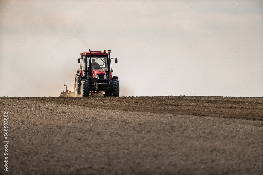 Fototapeta premium The dance of the tractor, cultivating the land in anticipation of new growth
