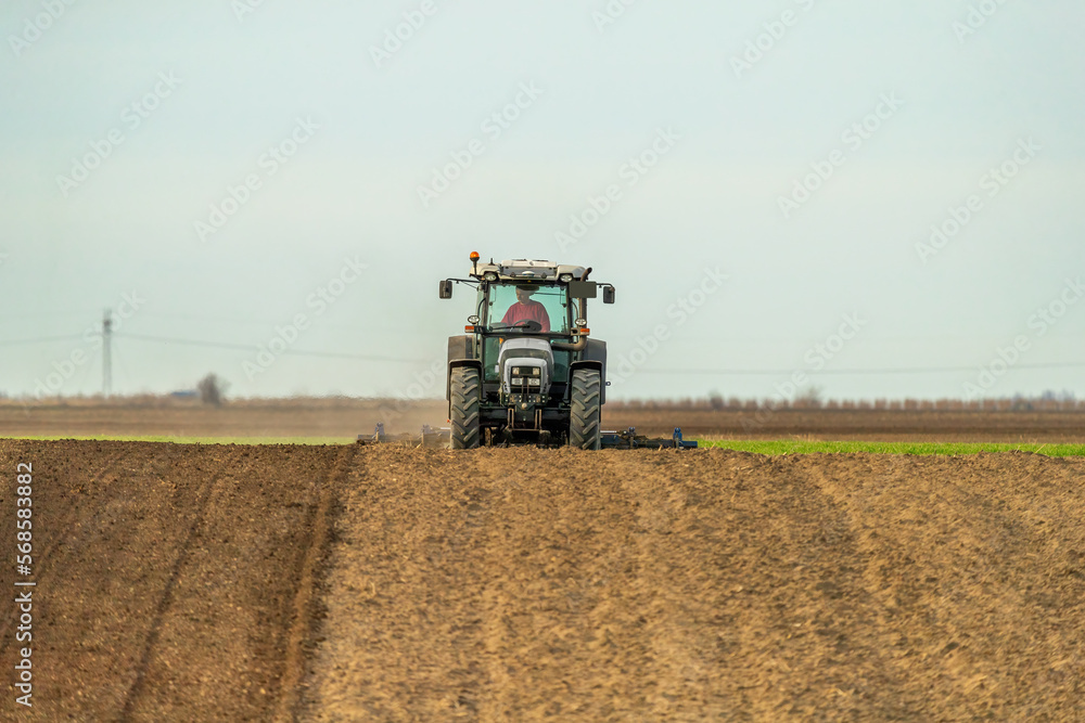 Obraz premium The heartbeat of the farm, tractor preparing the fields for a new cycle of life