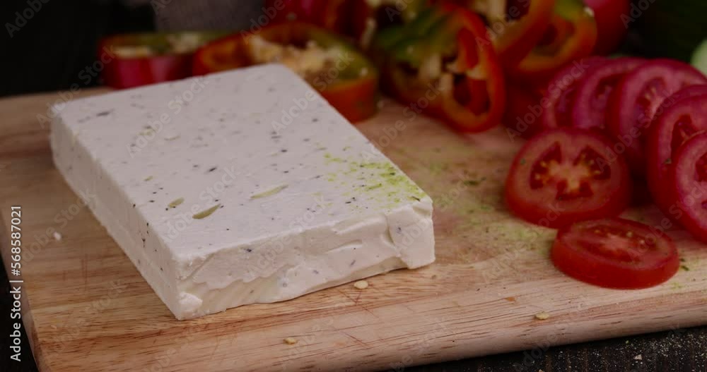 Slicing soft cream cheese for salads, slicing white cheese with spices and herbs during salad cooking Slicing soft cream cheese for salads, slicing white cheese with spices and herbs during salad cooking
