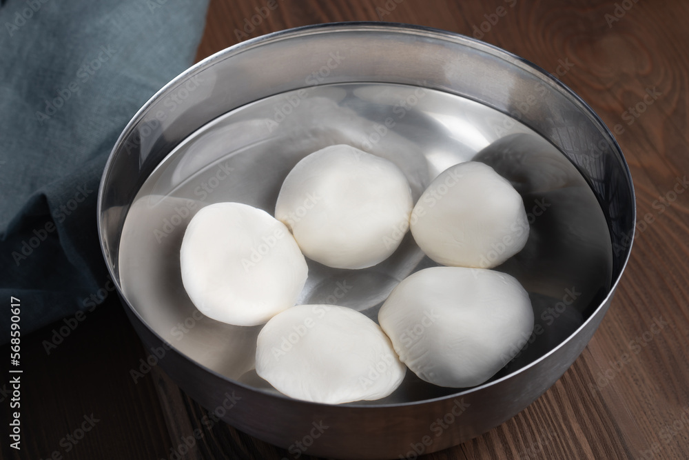 Making mozzarella cheese. Cooling the finished balls in cold water Stock  Photo | Adobe Stock