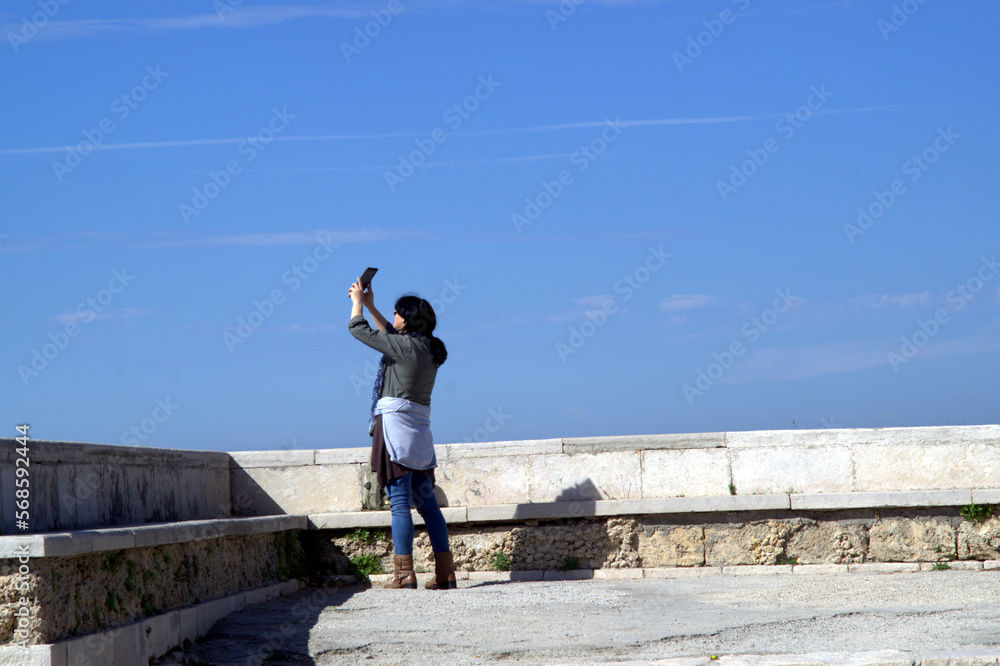 Giovane signora mentre usa il tablet computer sulla terrazza. Sud Europa