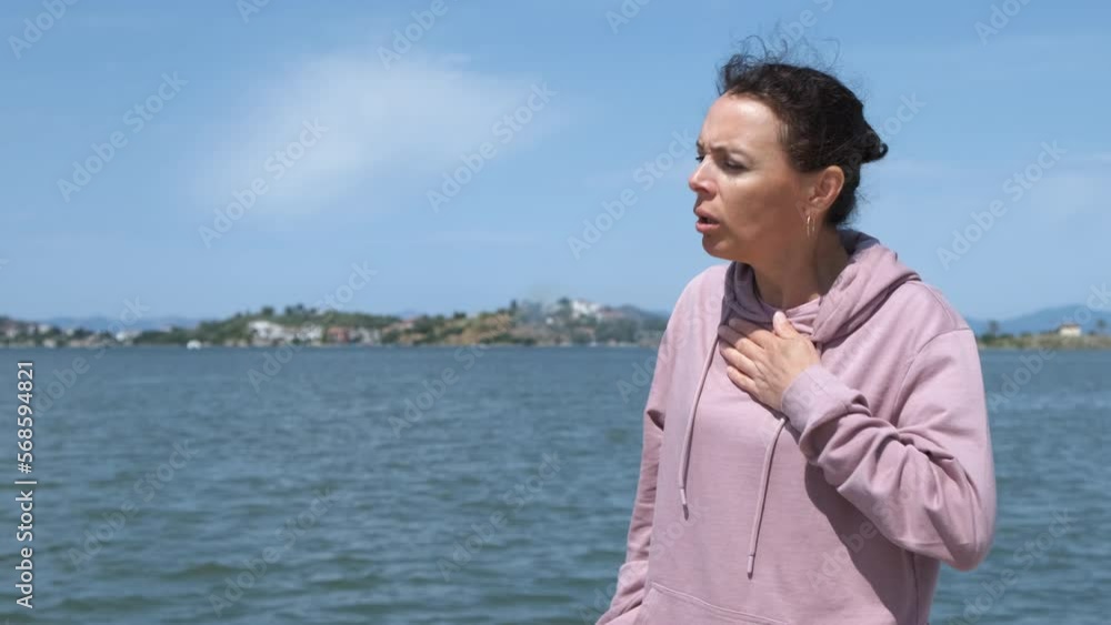 Difficult breathing. A female with difficulty breathing uses an inhaler. Difficult breathing. A female with difficulty breathing uses an inhaler.
