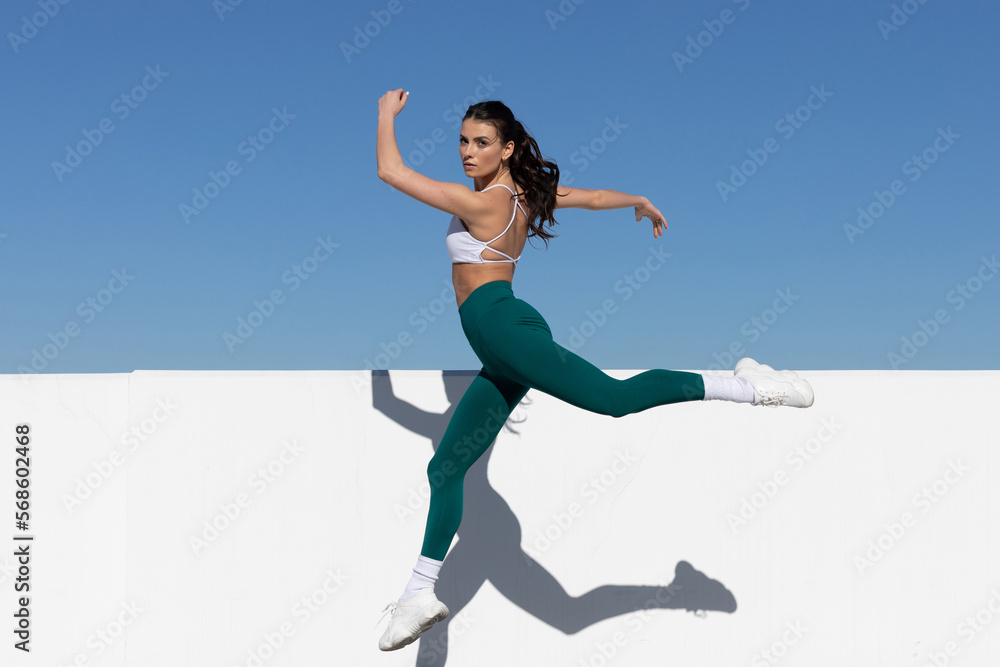 woman in exercise clothes jumping in the air, space for text woman in exercise clothes jumping in the air, space for text