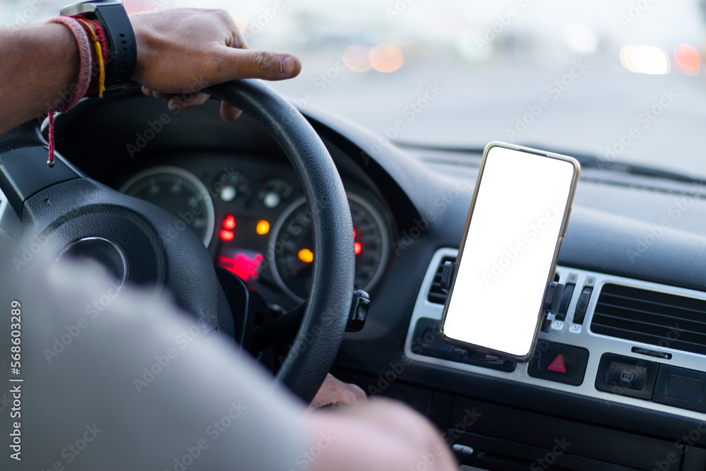 close up of a muckup in a smart phone mobile device into a car, with a hand on steering wheel