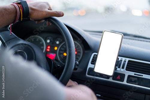 close up of a muckup in a smart phone mobile device into a car, with a hand on steering wheel © Alan