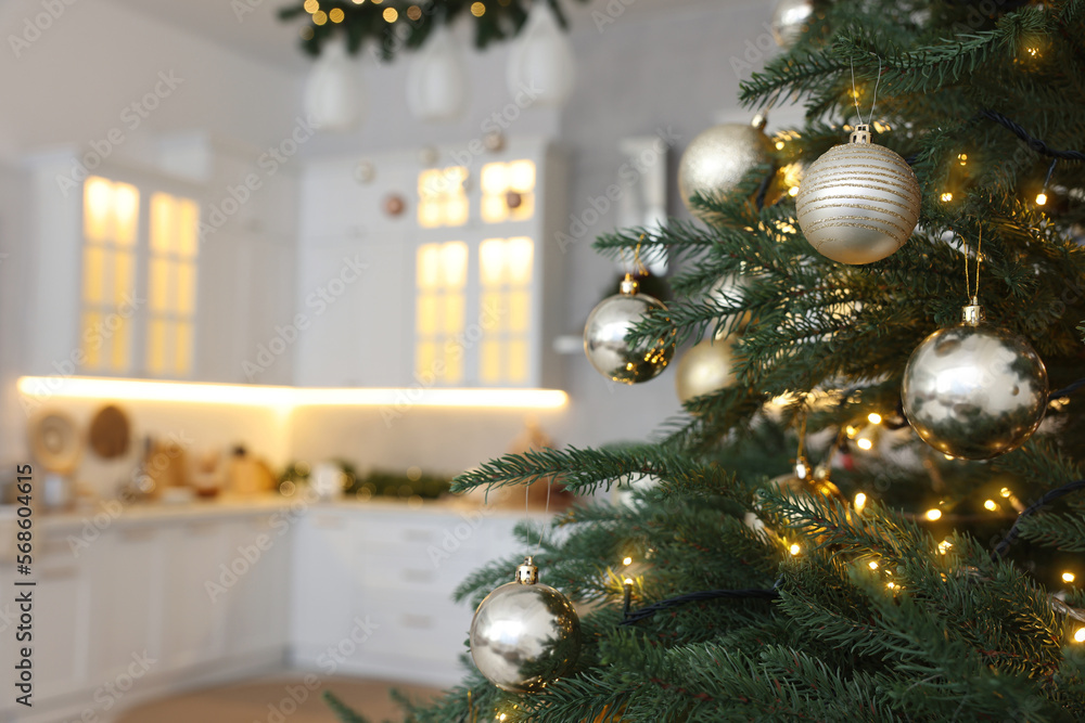 Closeup view of beautiful decorated Christmas tree in kitchen. Space for text