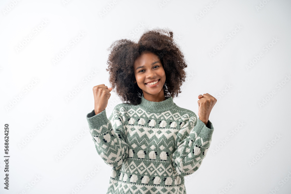 Portrait of young attractive african american woman with curly hair rejoicing success with clenched fists in studio on white background. Portrait of young attractive african american woman with curly hair rejoicing success with clenched fists in studio on white background.
