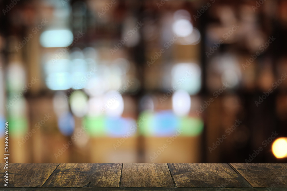 Empty dark wooden table in front of abstract blurred boken bankground of restaurant. Can used for display or montage your products. Mock up for space.