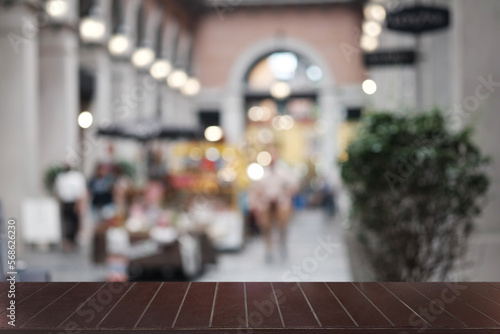 Empty dark wooden table in front of abstract blurred boken bankground of restaurant. Can used for display or montage your products. Mock up for space.