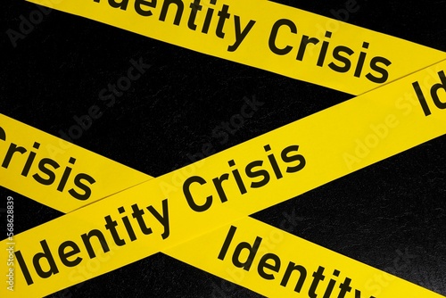 Obraz na płótnie Identity crisis problem caution and warning concept. Yellow barricade tape with word identity crisis in dark black background. w salonie