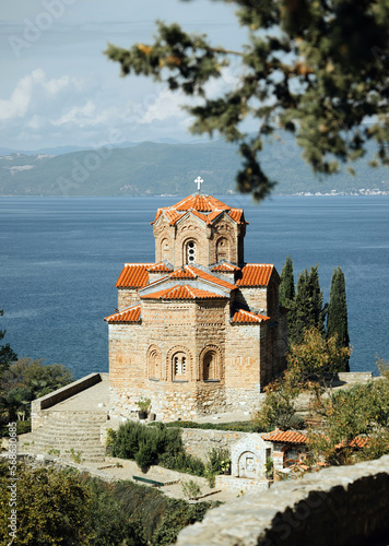The beautiful St. Kaneo church, perched on a cliff overlooking the stunning blue waters of Lake Ohrid, is a magnificent example of medieval architecture. (ID: 568630685)