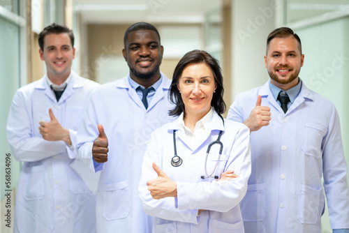 Group Of Happy multicultural doctors showing thumbs up and smiling. Portrait of multiracial medical specialists in white lab coats.
