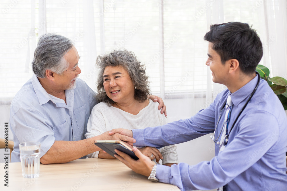 Obraz premium Asian senior couple shaking hands with doctor visit at home