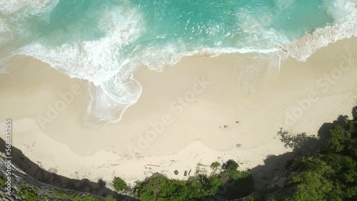 Top Down Aerial View, Breathtaking White Sand Beach on Remote Tropical Island, Sea Waves and Cliffs, High Angle Drone Shot photo