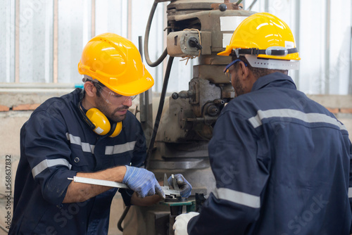 Engineer man training with foreman for apprentice using lathe, apprenticeship teaching with worker, technician and learning, inspector and labor, internship and workshop, industrial concept. photo