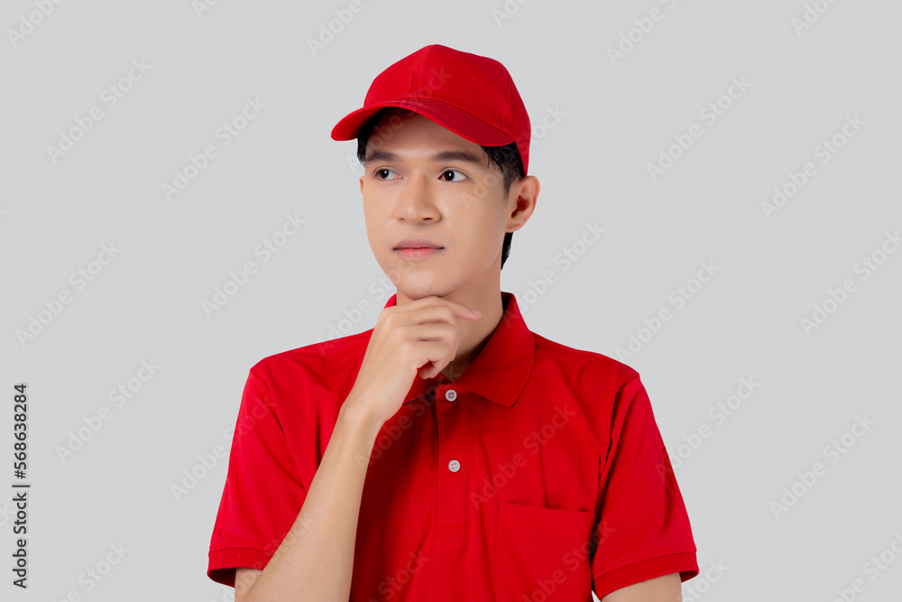 Young asian man in uniform red and cap standing and thinking idea isolated on white background, employee or dealer, courier and delivery, deliveryman and expression, logistic and cargo. Young asian man in uniform red and cap standing and thinking idea isolated on white background, employee or dealer, courier and delivery, deliveryman and expression, logistic and cargo.