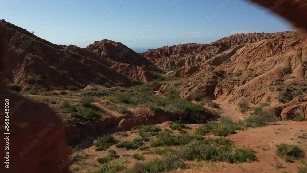 Scenic aerial view flying through a rock formation in Fairy Tale Canyon to reveal Issyk-Kul Lake, Kyrgyzstan. Scenic aerial view flying through a rock formation in Fairy Tale Canyon to reveal Issyk-Kul Lake, Kyrgyzstan.