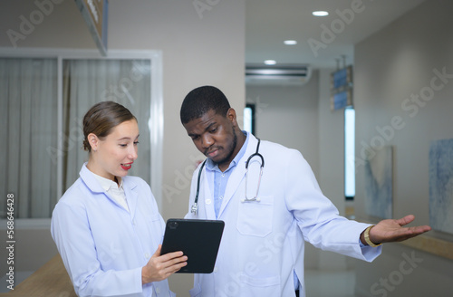 Both of doctors are analyzing the patient s MRI results on tablet to share ideas and discover new information for the patient s benefit in their treatment.