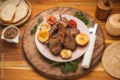 Lamp Rack Steak or Lamb chops Steak with rosemary, onion and tomato on wooden background.
