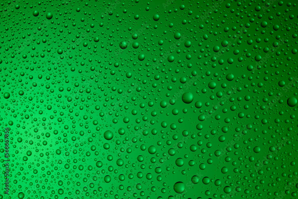 Bubbles and water drops in selective focus on glass, green background. ..
