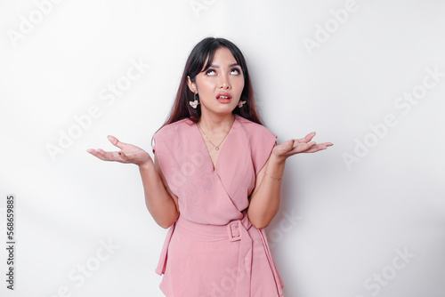 Konstfotografi Dissatisfied young Asian woman dressed in pink blouse rolling her eyes and raisi