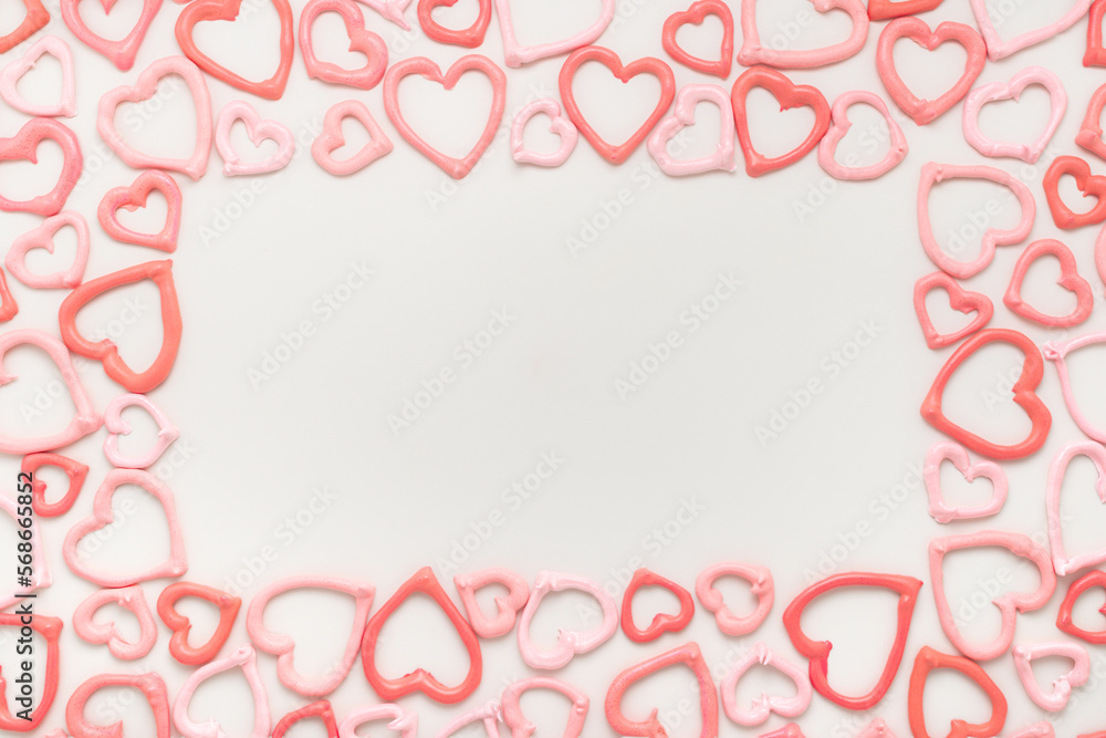 frame of sweet meringue kiss cookies of heart shapes over white background, concept of St. Valentines Day
