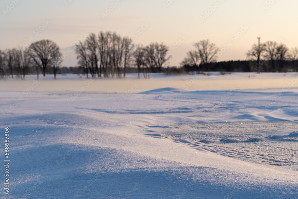 Winter sunset on the big river, hummocks in the rays of the sun.