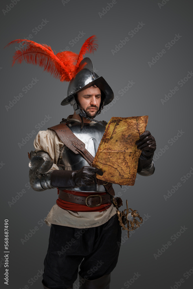 Studio shot of isolated on gray background conquistador with map. Studio shot of isolated on gray background conquistador with map.
