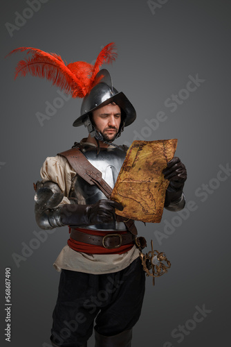 Studio shot of isolated on gray background conquistador with map.