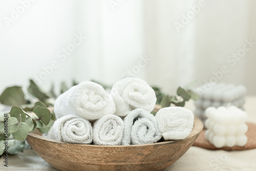 Spa composition with white towels in a wooden plate.