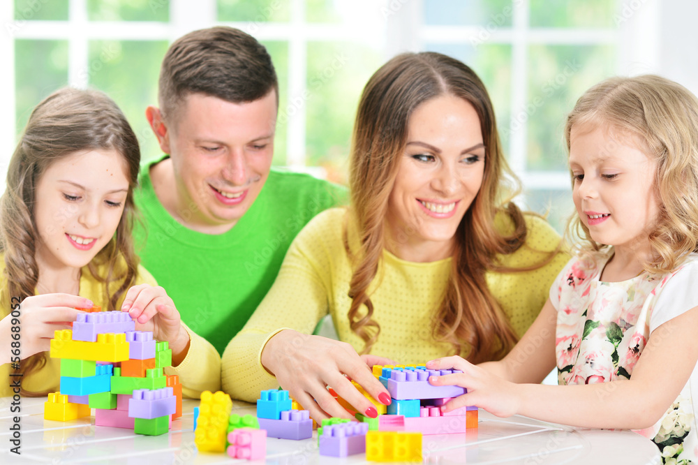 Girl with mother and father playing with wooden blocks Girl with mother and father playing with wooden blocks