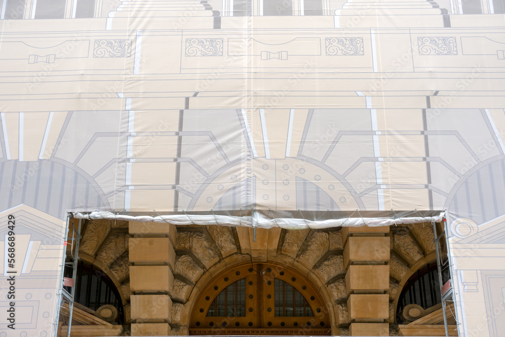 Fototapeta premium Facade of an old building covered with a print for restauration