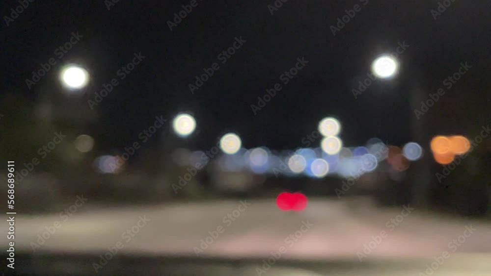 Blurred car lights bokeh in the evening city. Defocused headlights and street lighting at night. Moving bokeh circles of cars at night. Blurred city traffic background Blurred car lights bokeh in the evening city. Defocused headlights and street lighting at night. Moving bokeh circles of cars at night. Blurred city traffic background
