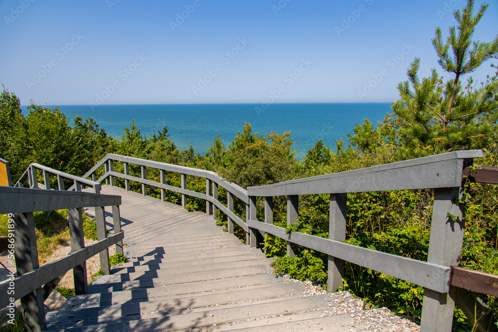wooden walking path and stairs by the sea in Jastrzebia Góra Poland on a warm summer holiday day